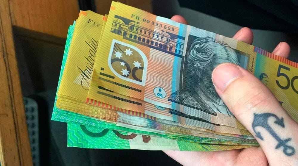 Mano con billetes dollares australianos